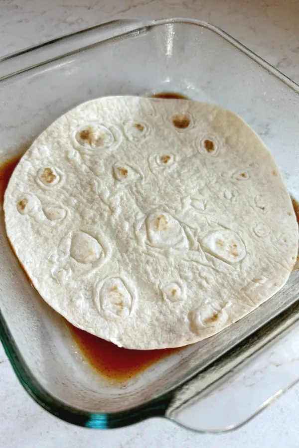 tortilla shell on red enchilada sauce 