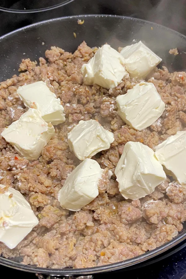 cubes of cream cheese on cooked ground meat