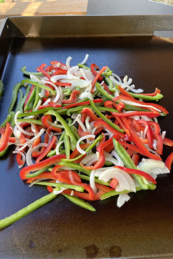 pile of red pepper, green pepper and onions on a Blackstone griddle