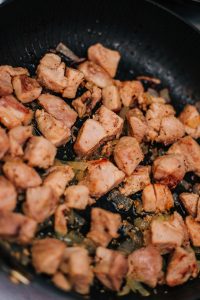 browning diced chicken in cast iron skillet