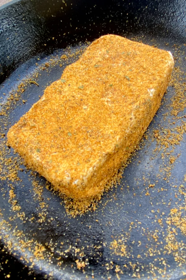 dry rub seasoning on block of cheese 
