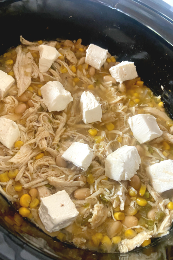 dollops of cream cheese on top of shredded white chicken chili