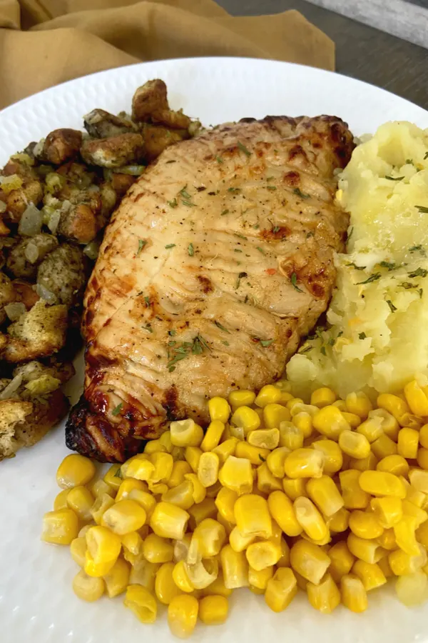 turkey tenderloin on plate with thanksgiving side dishes 