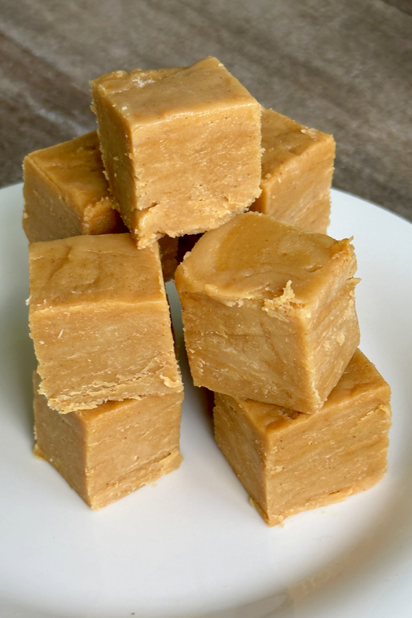 easy peanut butter fudge stacked on a white plate 