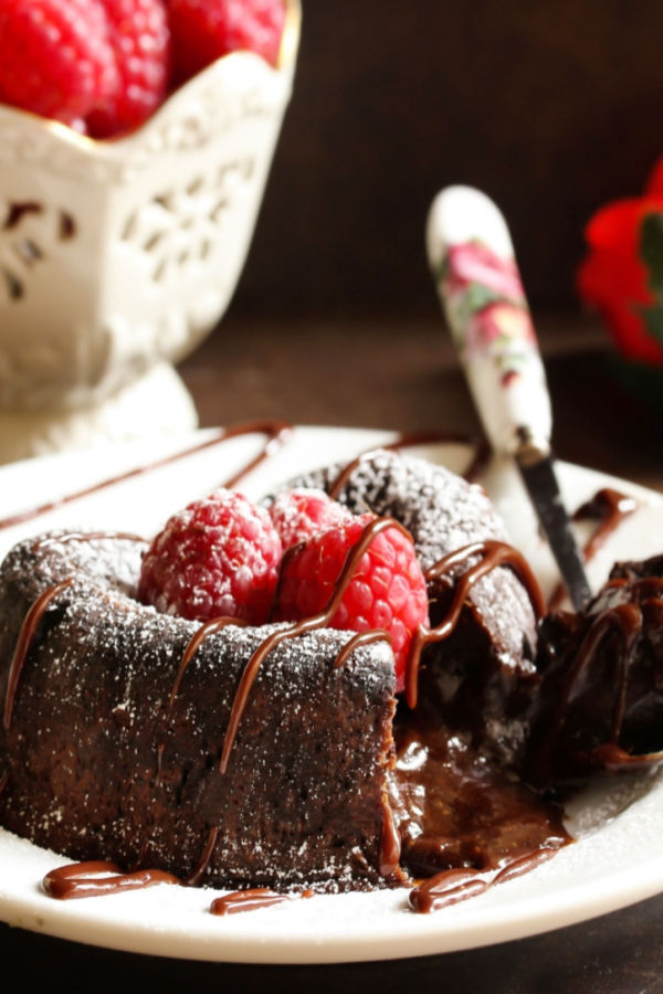 chocolate lava cake with raspberries and powdered sugar on top