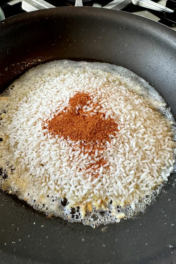rice with seasoning in skillet 