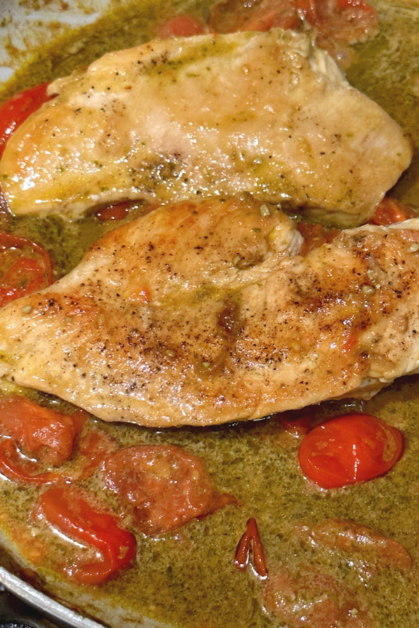 chicken and tomatoes in pesto sauce in skillet 