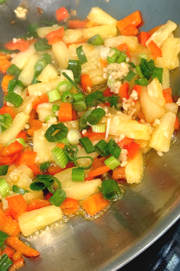 pineapple red pepper green onion and garlic in skillet 