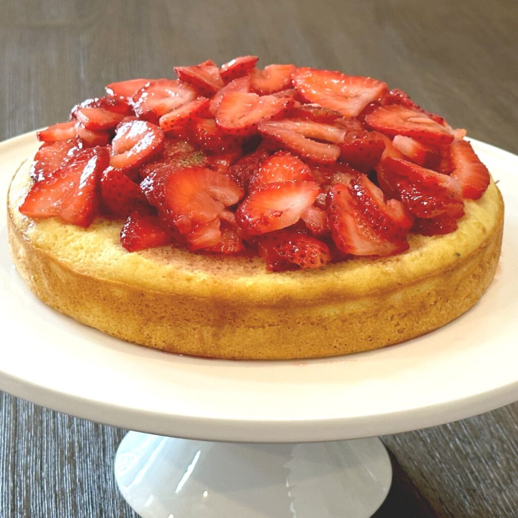 strawberry shortcake on white cake pedestal 