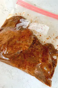 chicken marinating in resealable plastic bag