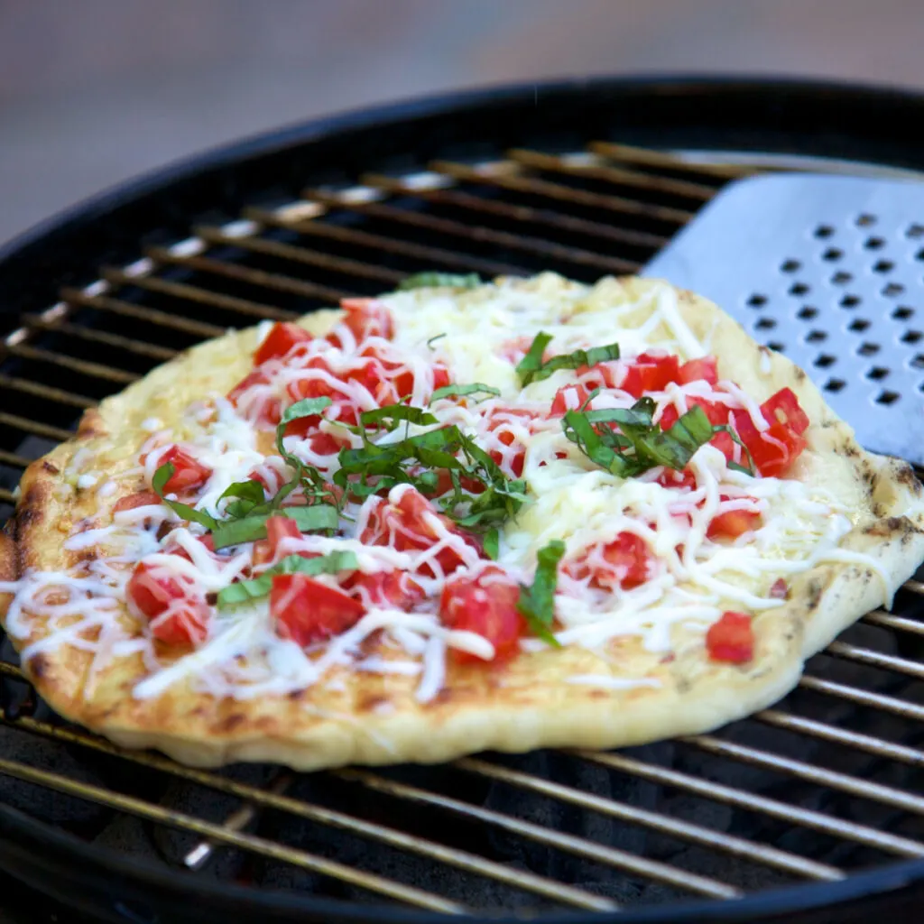 spatula removing flat bread from grates