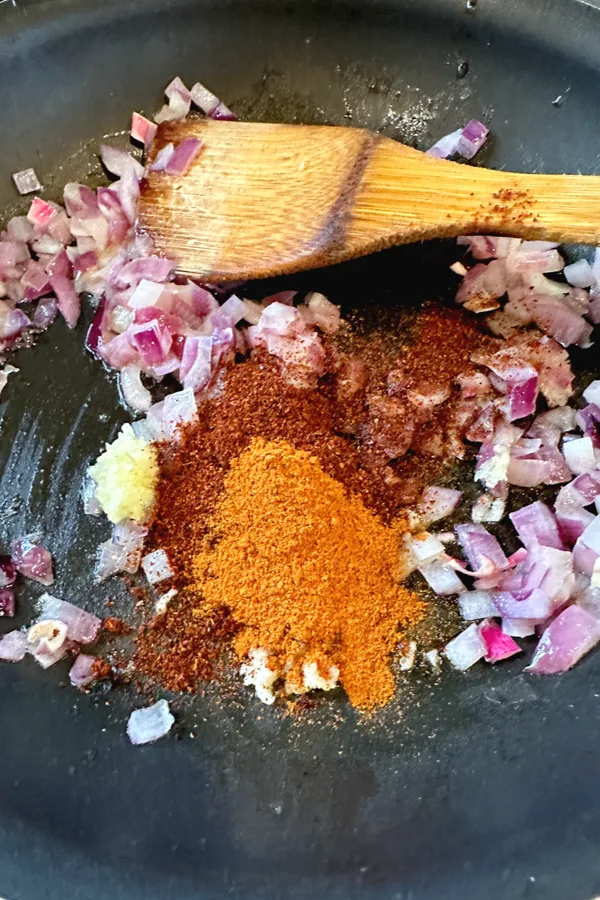 diced red onion and spices in skillet 