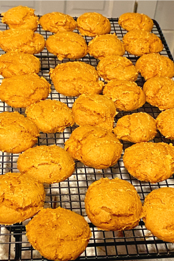 pumpkin cookies on a cooling rack waiting to be topped with cream cheese frosting