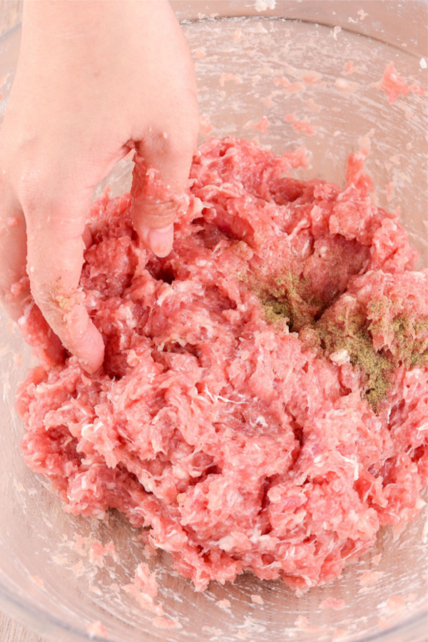 ground beef being mixed by hand.
