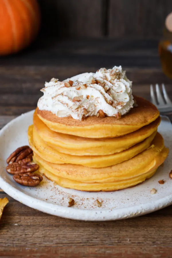 pumpkin spice pancakes with whipped cream and nuts 