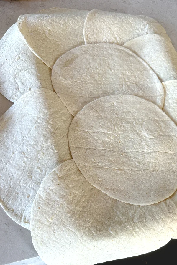 tortillas layered on top of a sheet pan