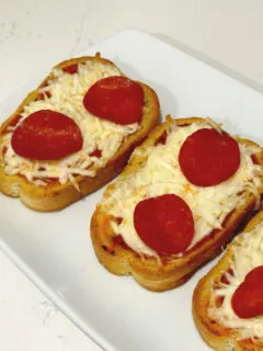 garlic toast pizza on white plate