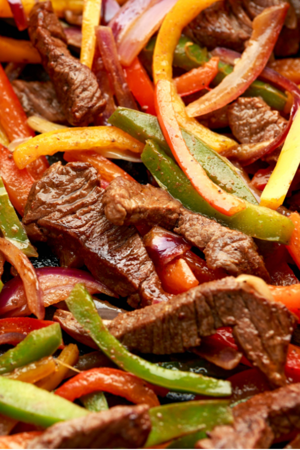 steak, peppers and onions cooked for sheet pan steak fajitas