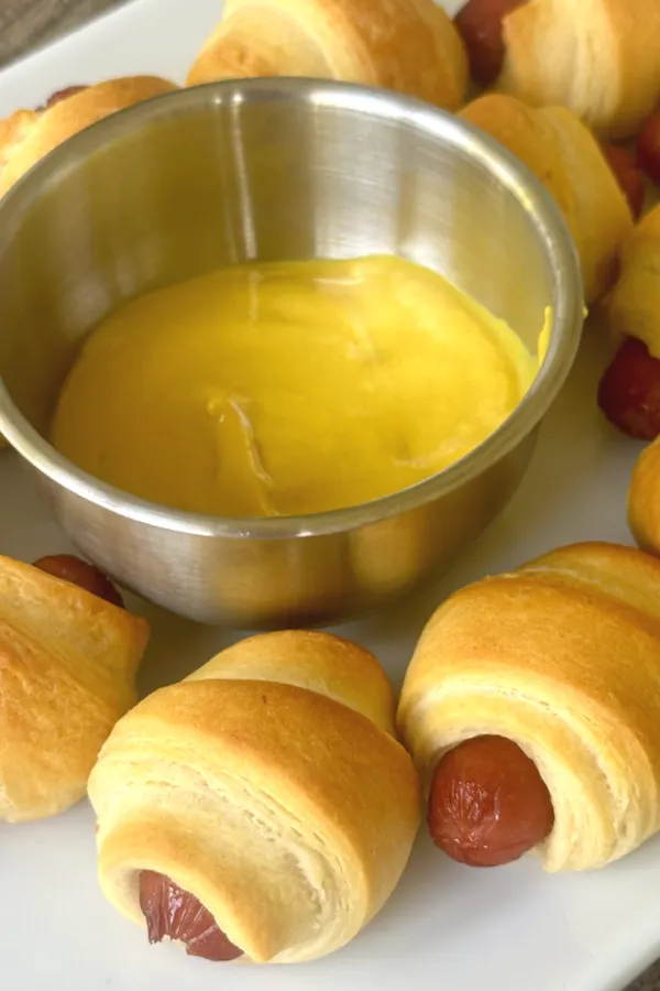 mini pigs in a blanket served with mustard for dipping 