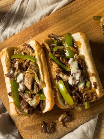 Philly cheesesteak hoagies on cutting board