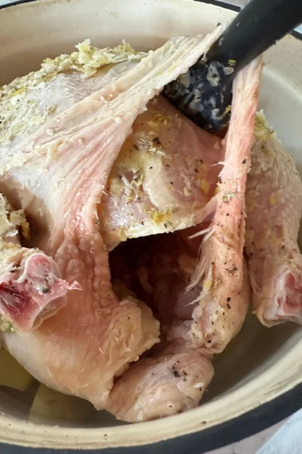 butter under skin of whole chicken in a dutch oven